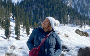 Wisatawan bermain salju di Gulmarg, Kashmir, dengan latar pegunungan Himalaya bersalju.